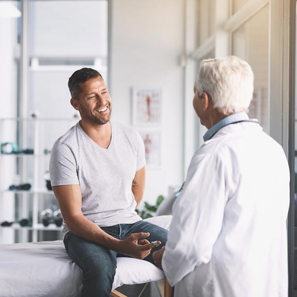 man talking to doctor in office