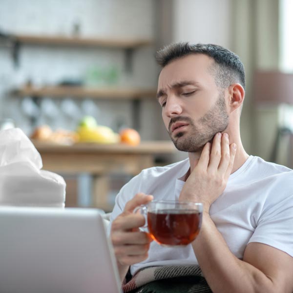 man holding throat in pain