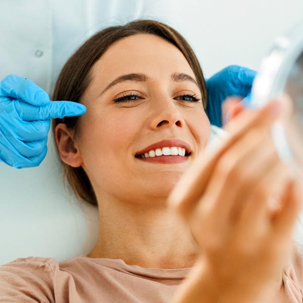 woman looking at results after facial surgery