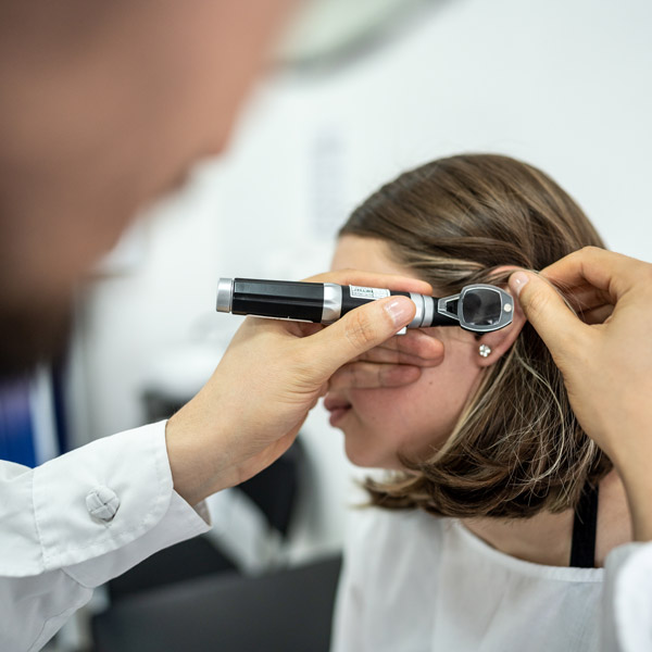 girl getting hearing exam in doctor's office