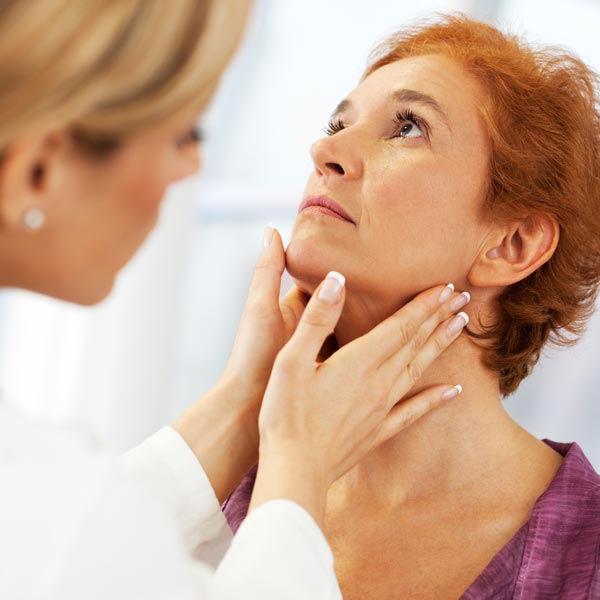 doctor examining female patient's throat