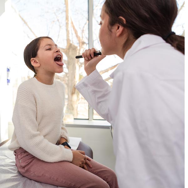 doctor examining young patient's throat
