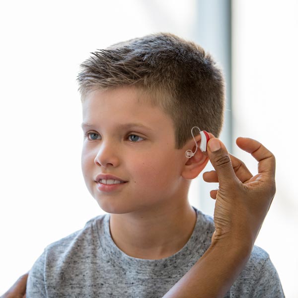 little boy being fitted for a hearing aid