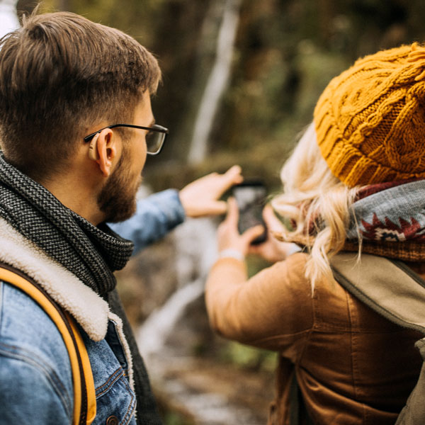 man with hearing aid and woman on a hike